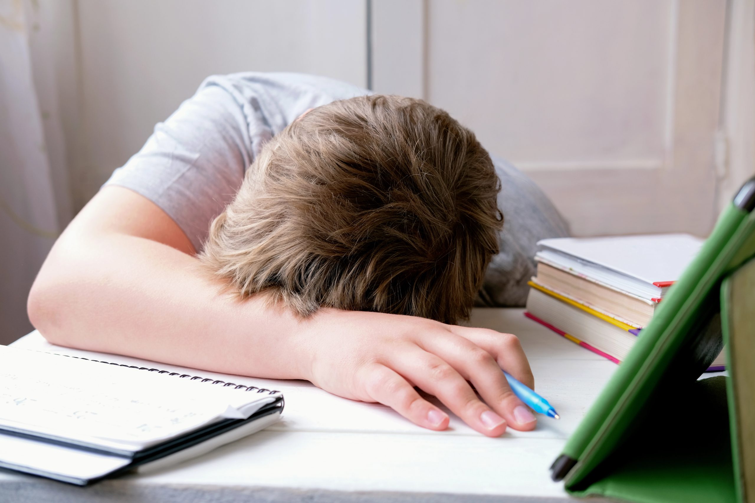 tired-boy-laying-table-top-Depositphotos_369931188_XL